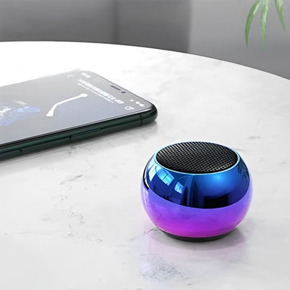 Enceinte bluetooth sphérique design irisé à coté téléphone portable