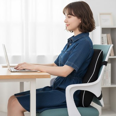 femme assise avec coussin lombaire devant bureau