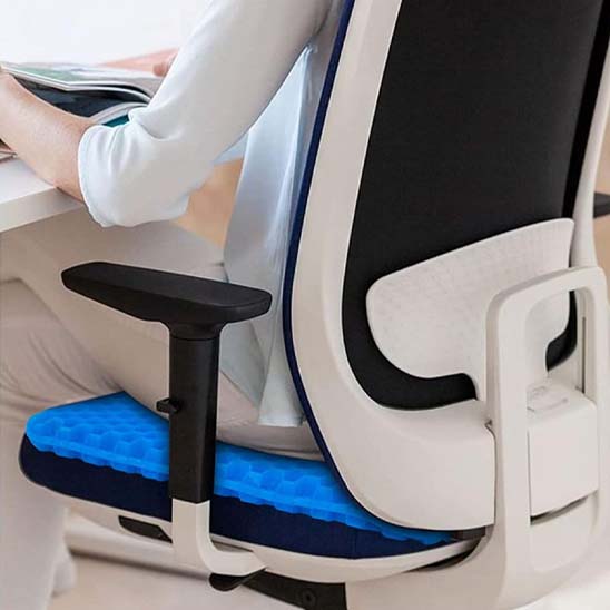 femme de dos assise sur coussin ergonomique nid d'abeille sur siège bureau