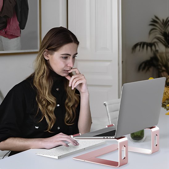 femme devant support ordinateur portable couleur rose dans bureau