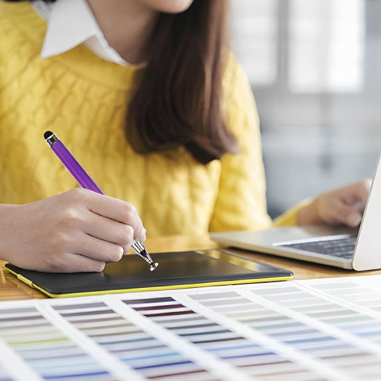 femme pull jaune tenant stylet tablette violet