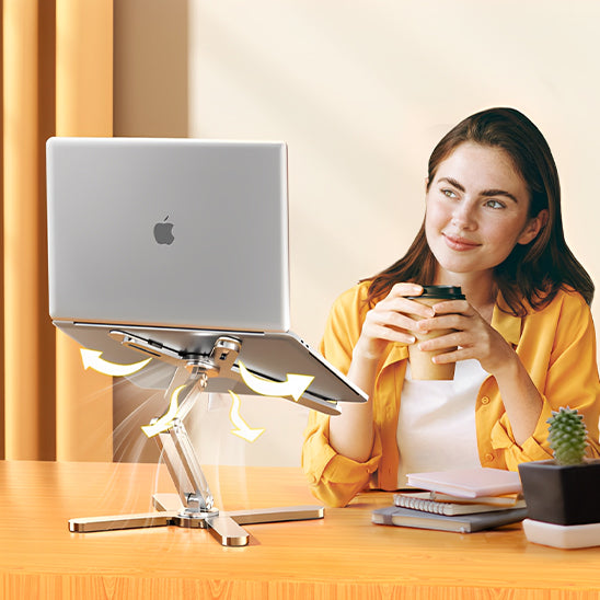 femme souriante tenant un café assise devant support ordinateur portable