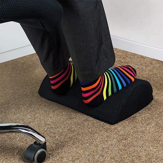 homme assis avec pieds sur repose pied pour bureau