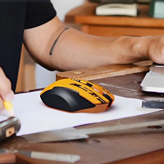 homme assis devant bureau avec souris gaming sans fil 