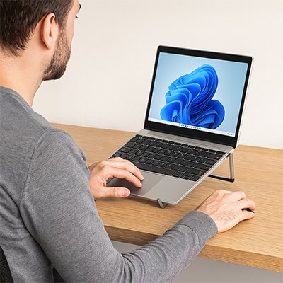 homme assis devant rehausseur ordinateur portable avec ordinateur