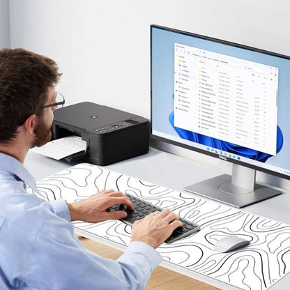 homme assis devant sous main bureau devant écran ordinateur