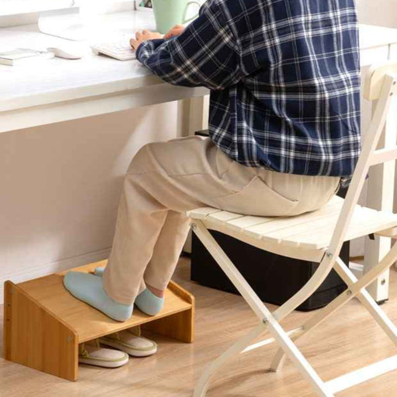 homme chemise bleue assis bureau pieds sur repose pied bureau 