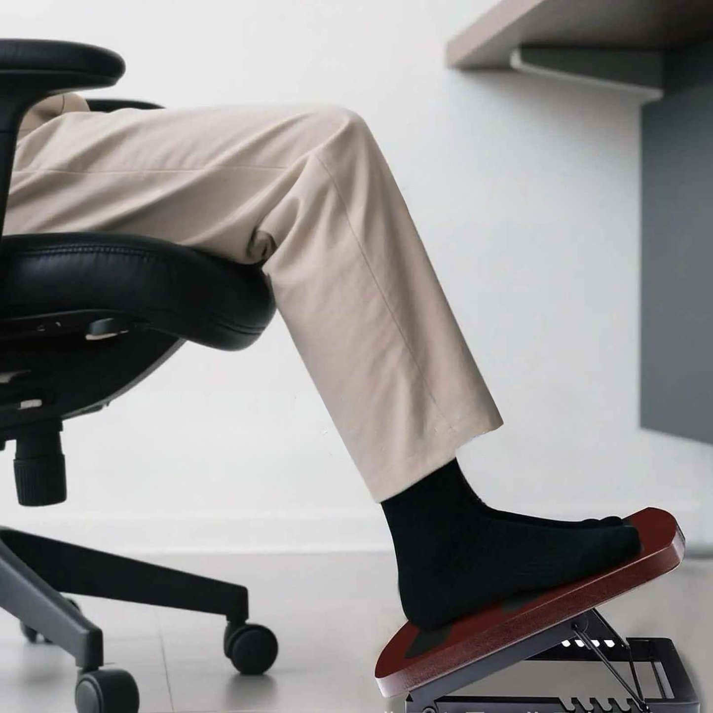 homme dans bureau pieds sur repose-pieds bureau en bois