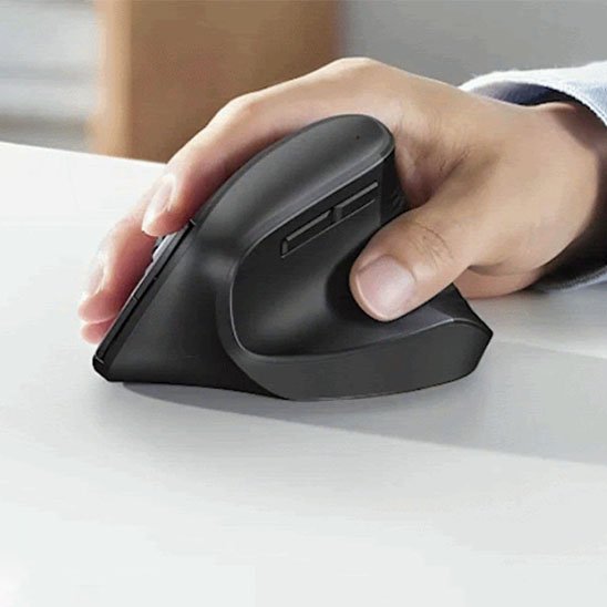 main posée sur souris ergonomique verticale sur bureau