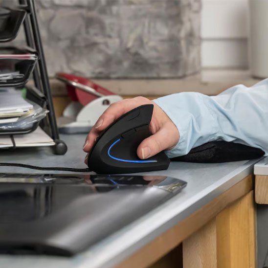 main tenant souris ergonomique sur bureau gris
