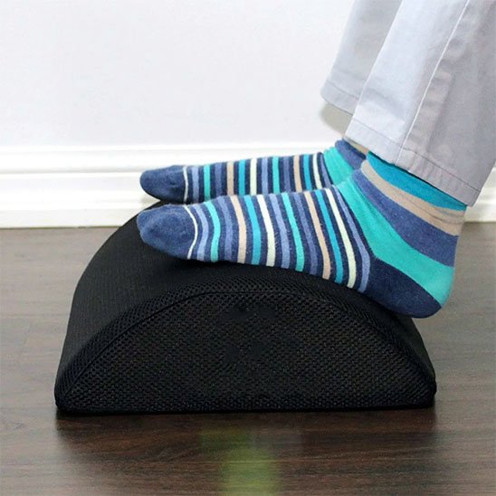 pieds avec chaussettes bleues sur repose pied pour bureau