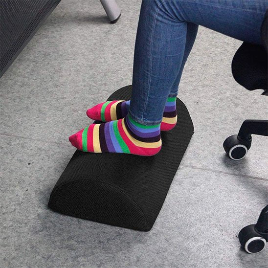 pieds avec chaussettes multicolores sur repose pied pour bureau