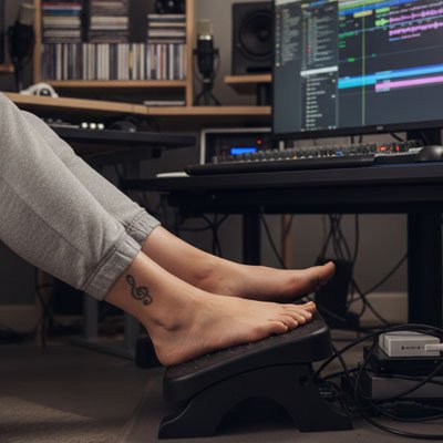 pieds sur repose pieds bureau noir