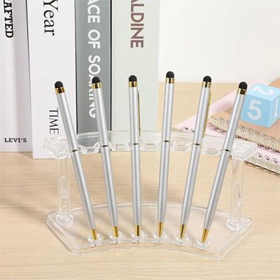 Porte stylo en plastique transparent posé devant livres