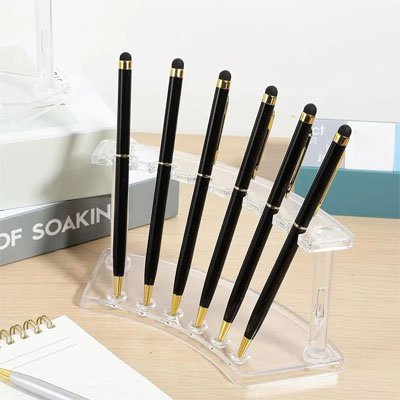 Porte stylo en plastique transparent posé sur bureau avec stylos